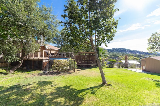 view of yard with a swimming pool side deck with mountain view