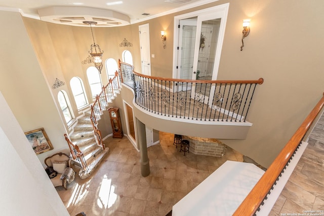 staircase featuring crown molding and a towering ceiling