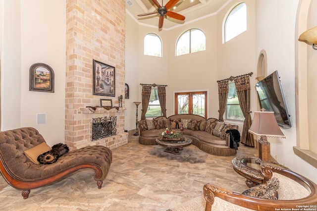 living room with crown molding, ceiling fan, and a brick fireplace