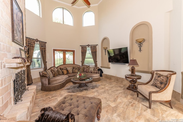 living room featuring ornamental molding, a brick fireplace, and ceiling fan