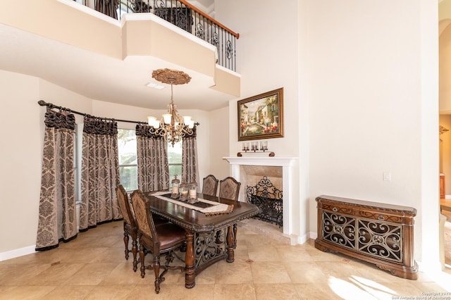 dining room with a notable chandelier, a high end fireplace, and a high ceiling