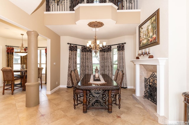 dining area featuring a high ceiling, decorative columns, and an inviting chandelier