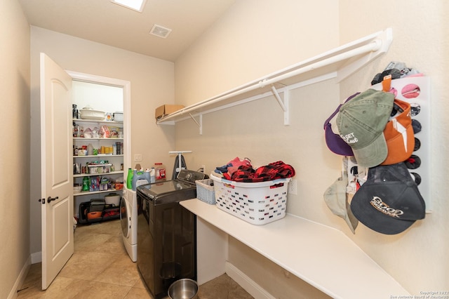 laundry area with separate washer and dryer and light tile patterned floors