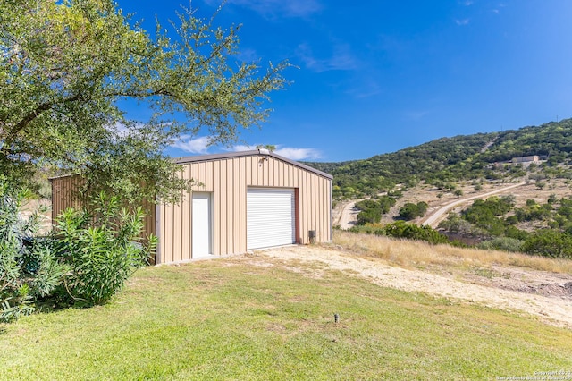 garage featuring a mountain view and a lawn