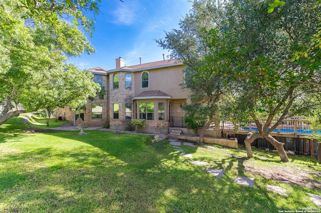 rear view of property with a lawn