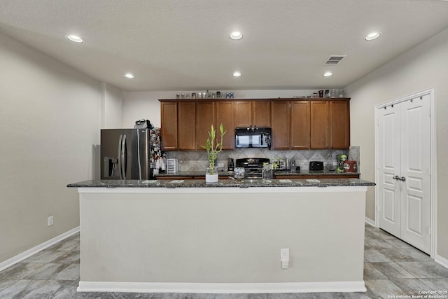 kitchen with a kitchen island with sink, stainless steel fridge with ice dispenser, decorative backsplash, and stove