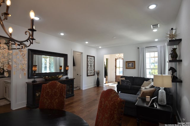 living room with a notable chandelier and dark hardwood / wood-style floors