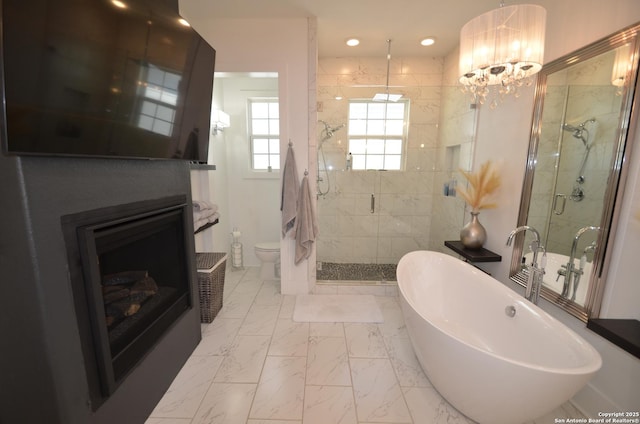 bathroom with shower with separate bathtub, a notable chandelier, and toilet