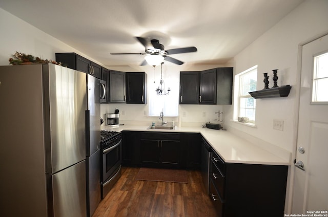 kitchen featuring dark hardwood / wood-style flooring, sink, stainless steel appliances, and ceiling fan