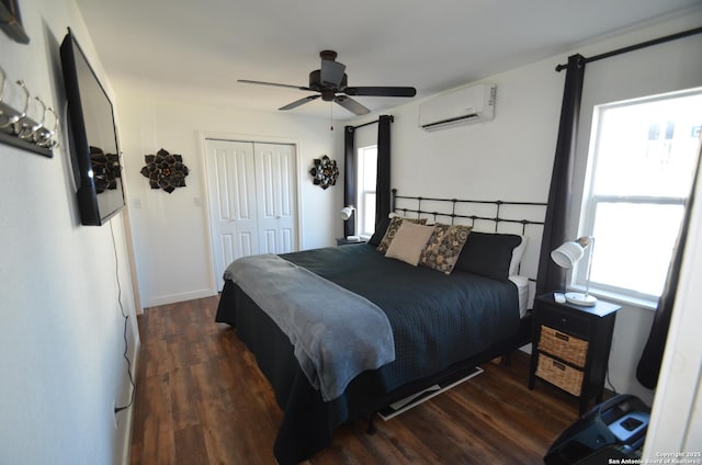 bedroom featuring dark hardwood / wood-style flooring, a wall unit AC, a closet, and ceiling fan