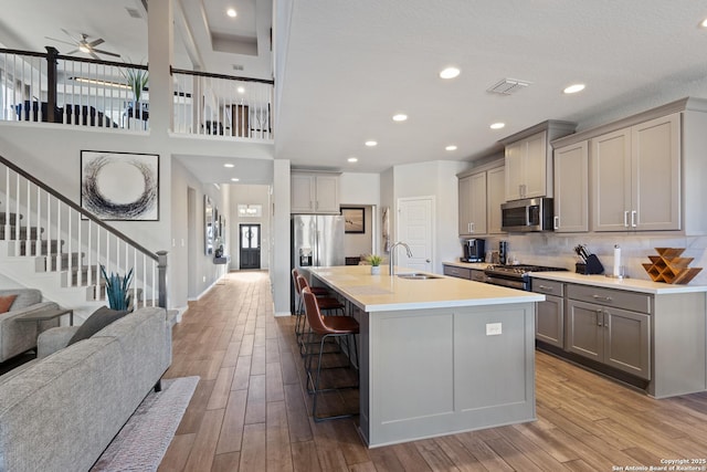 kitchen featuring gray cabinetry, sink, a breakfast bar area, and stainless steel appliances