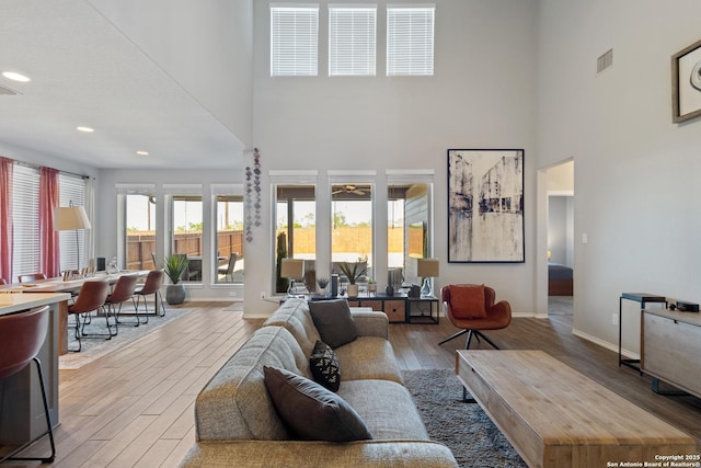 living room with hardwood / wood-style flooring and a towering ceiling