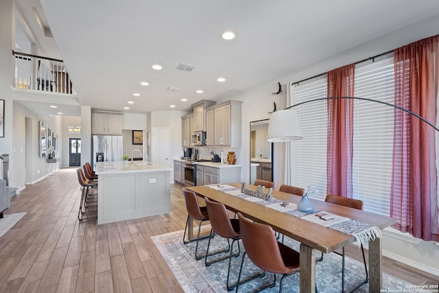 dining area with light hardwood / wood-style floors, sink, and a wealth of natural light