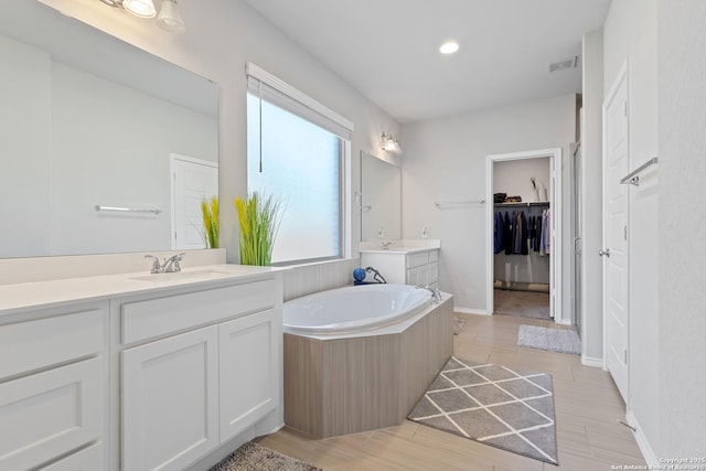 bathroom featuring vanity, wood-type flooring, and a washtub