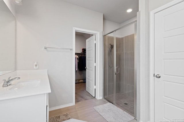 bathroom featuring vanity and a shower with door