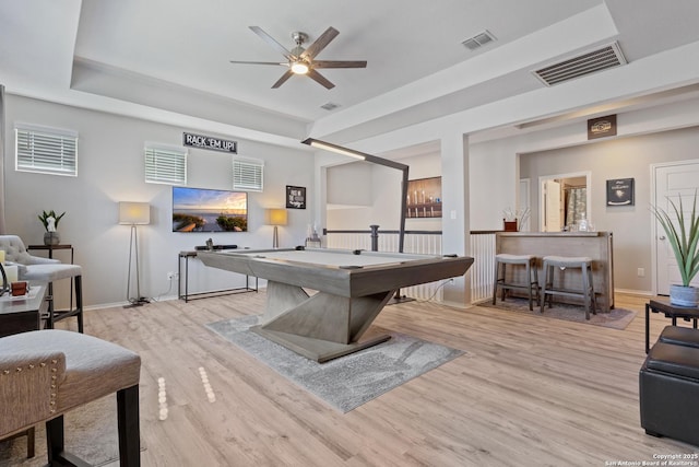 game room with ceiling fan, pool table, light wood-type flooring, and a tray ceiling