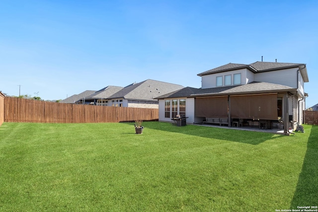 back of house with a patio and a lawn