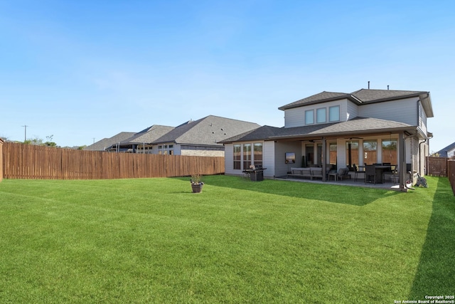 rear view of house featuring a yard and a patio area