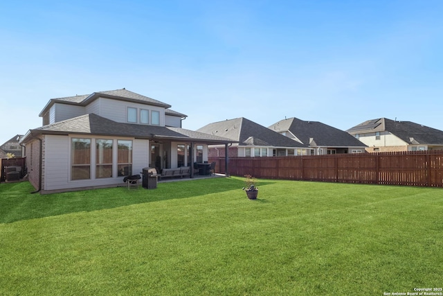 rear view of property with a yard and a patio