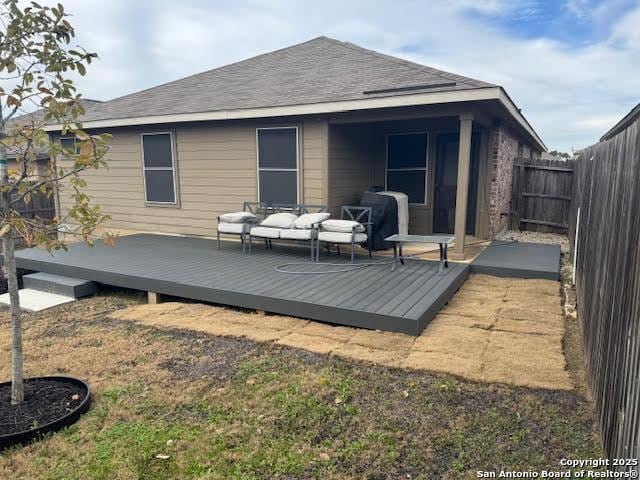 back of house with a wooden deck, a yard, and an outdoor hangout area