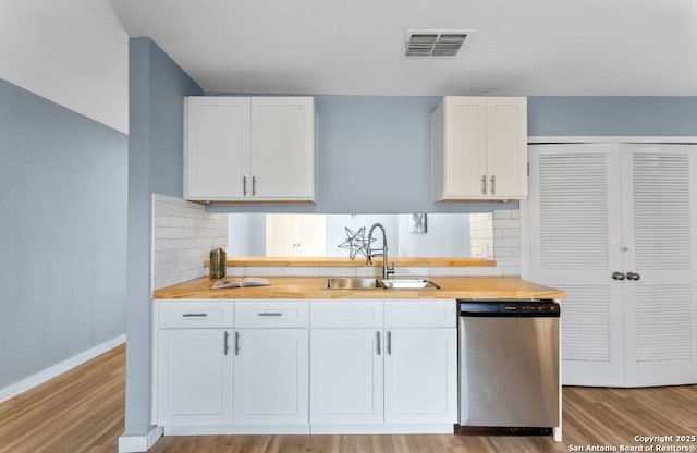 kitchen featuring white cabinetry, dishwasher, sink, and light hardwood / wood-style flooring