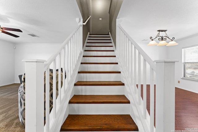 stairway with ornamental molding, a textured ceiling, and ceiling fan