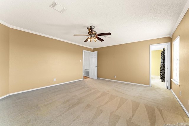 carpeted spare room with ceiling fan, ornamental molding, and a textured ceiling