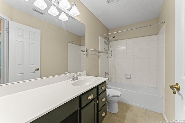 full bathroom featuring tile patterned flooring, vanity, tiled shower / bath combo, toilet, and a textured ceiling