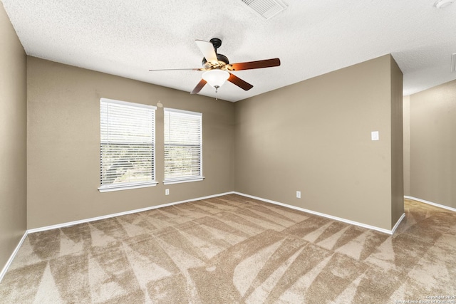 carpeted spare room with a textured ceiling and ceiling fan