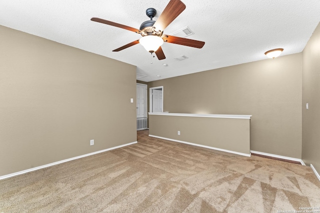 unfurnished room with ceiling fan, a textured ceiling, and carpet flooring