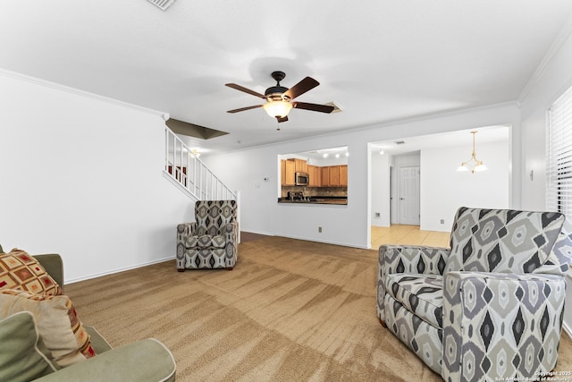 carpeted living room with ornamental molding and ceiling fan with notable chandelier