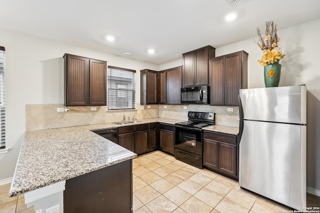 kitchen with light tile patterned floors, backsplash, dark brown cabinets, light stone countertops, and black appliances