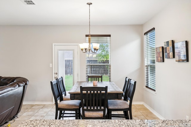 tiled dining room with a chandelier