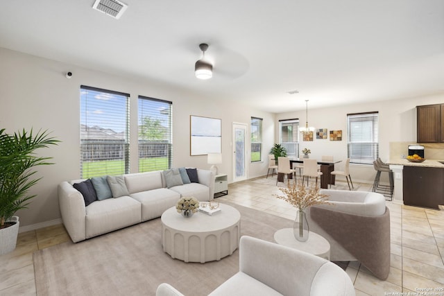 living room featuring an inviting chandelier and light tile patterned flooring