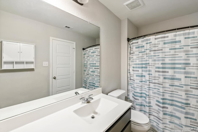 bathroom featuring walk in shower, vanity, and toilet