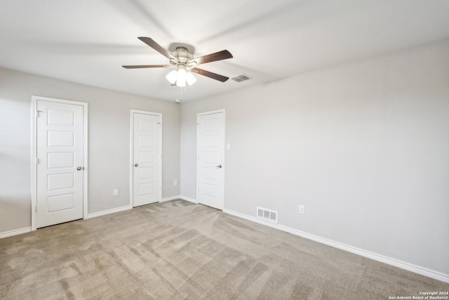 unfurnished bedroom featuring ceiling fan and light colored carpet