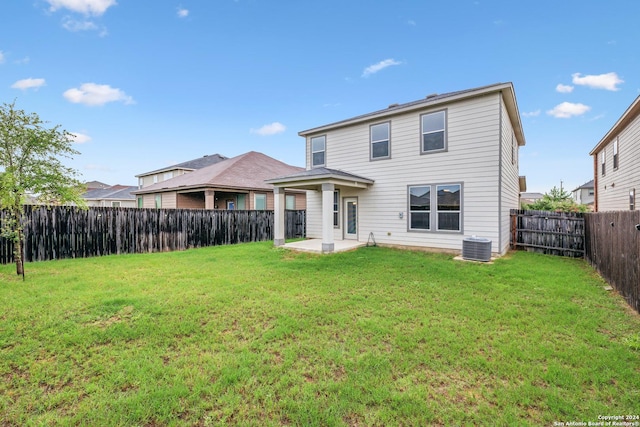 back of house with central AC unit, a yard, and a patio area