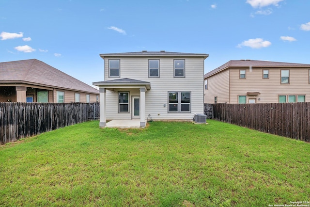 rear view of house with central AC, a patio area, and a lawn