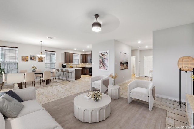 living room featuring light tile patterned floors and a chandelier