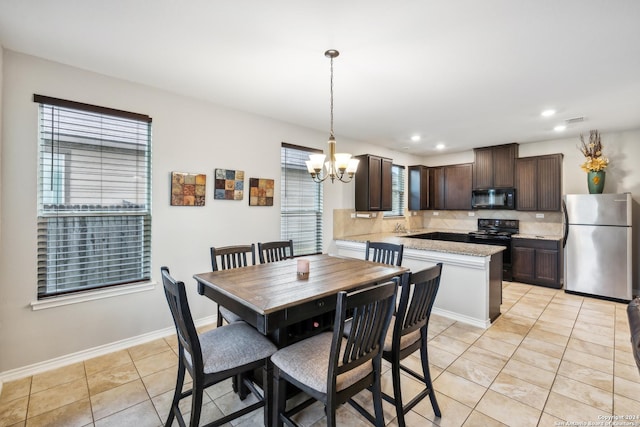 dining area with an inviting chandelier, plenty of natural light, and light tile patterned floors