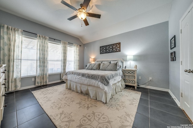 bedroom featuring ceiling fan, lofted ceiling, and dark tile patterned flooring