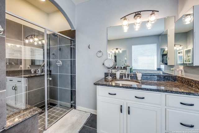 bathroom featuring vanity, a shower with shower door, and tile patterned flooring