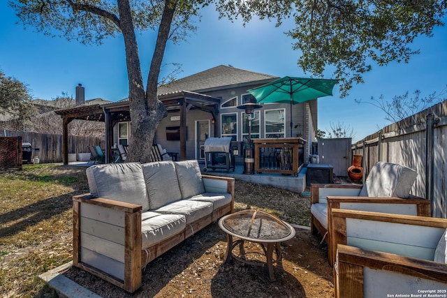 rear view of property featuring an outdoor living space with a fire pit