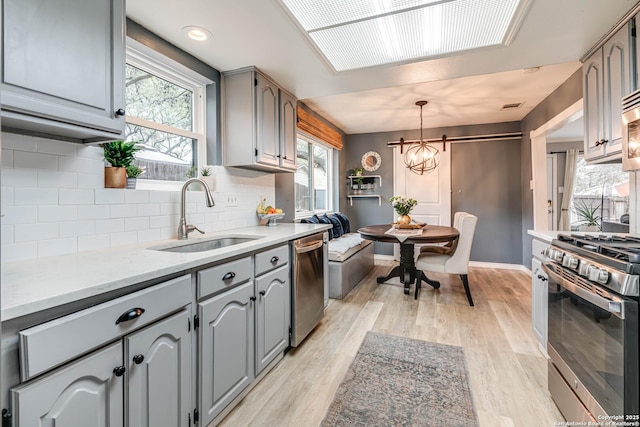 kitchen featuring appliances with stainless steel finishes, sink, and gray cabinetry