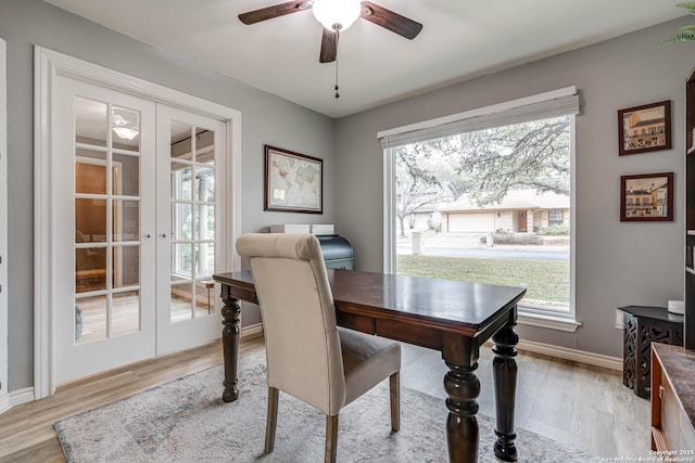 home office with light hardwood / wood-style flooring, a wealth of natural light, french doors, and ceiling fan