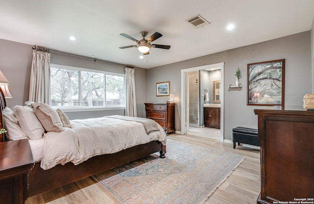 bedroom with ceiling fan, connected bathroom, and light wood-type flooring