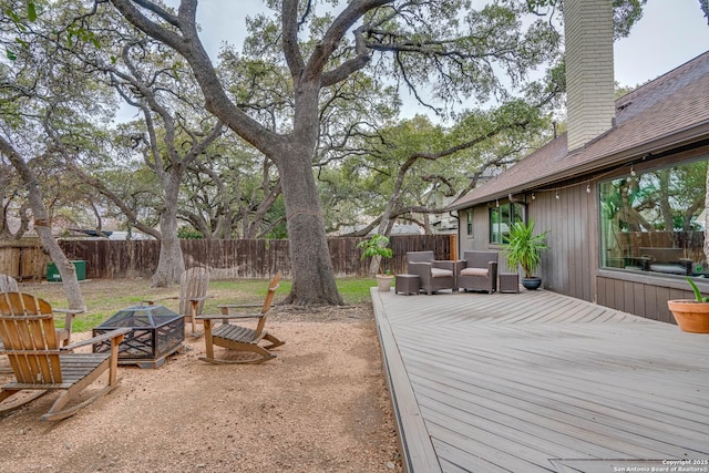 view of yard featuring a wooden deck and an outdoor living space with a fire pit