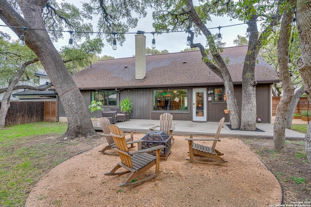 rear view of property with a fire pit