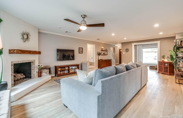 living room with crown molding, ceiling fan, and light hardwood / wood-style floors