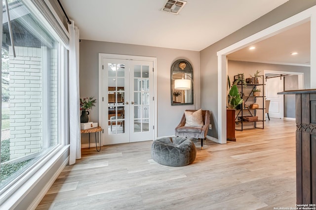 sitting room featuring french doors and light hardwood / wood-style floors